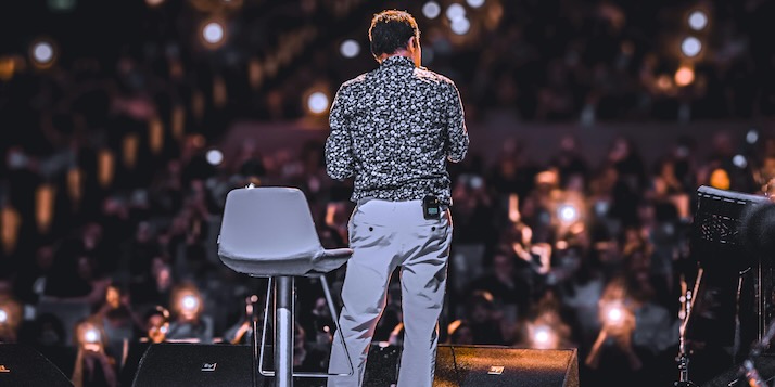 Back View of Speaker on Stage with Audience Lights