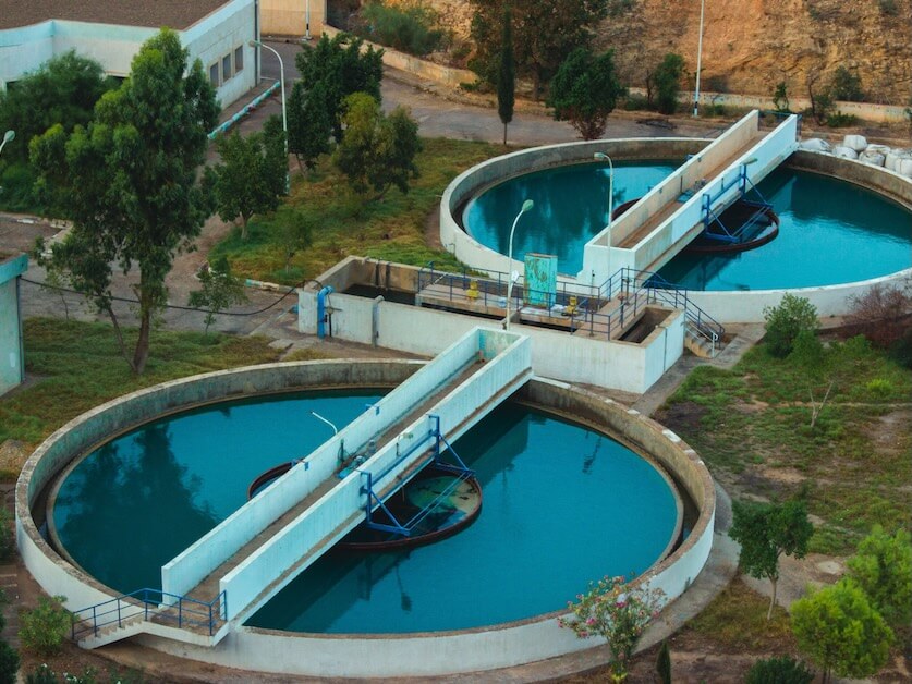 Drone shot of an advanced water purification plant surrounded by trees.