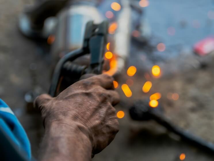 a man holding a welding gun in his right hand