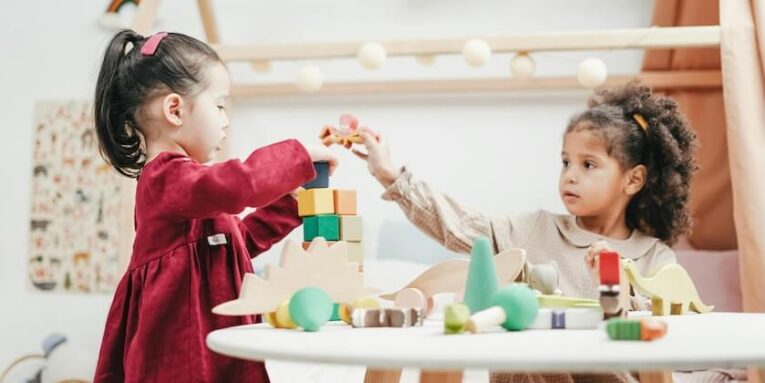Girl In Red Dress Playing A wooden Blocks FEATURED IMAGE