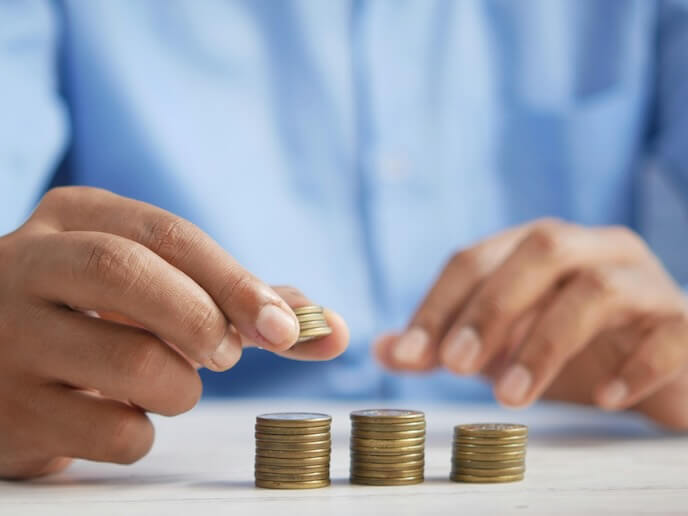 a person stacking coins on top of a table