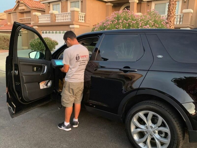 a man opening the door of a black suv
