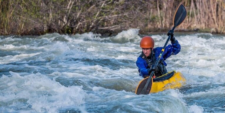 Photo of Man Paddling Kayak in Raging River FEATURED IMAGE
