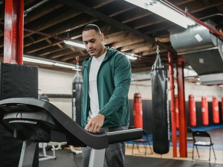 Man regulating speed on modern treadmill