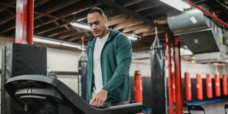 Man regulating speed on modern treadmill FEATURED IMAGE