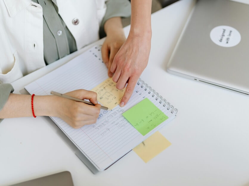 Person Writing on a Notebook
