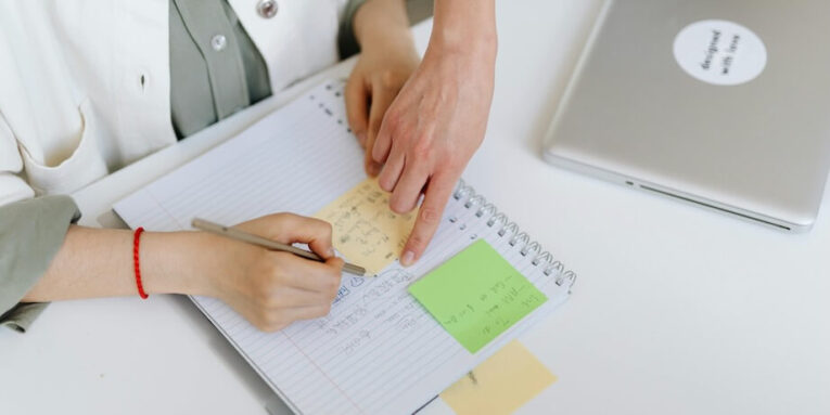 Person Writing on a Notebook