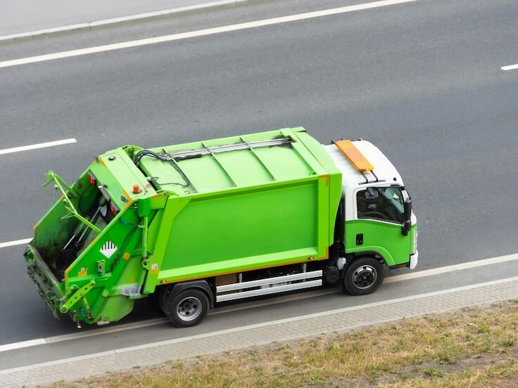 recycling green eco-truck rides on the road in the city
