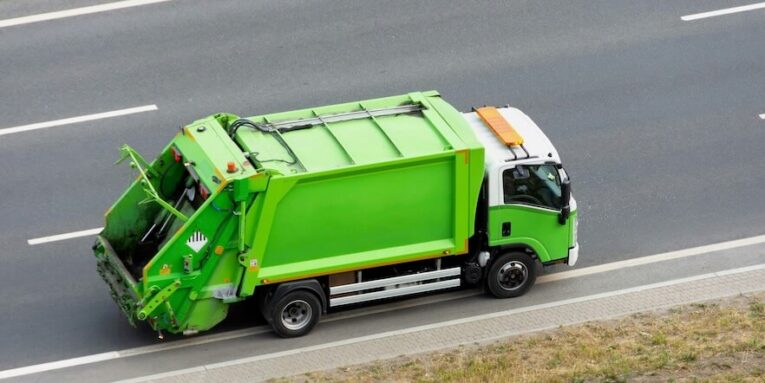 recycling green eco-truck rides on the road in the city FEATURED IMAGE