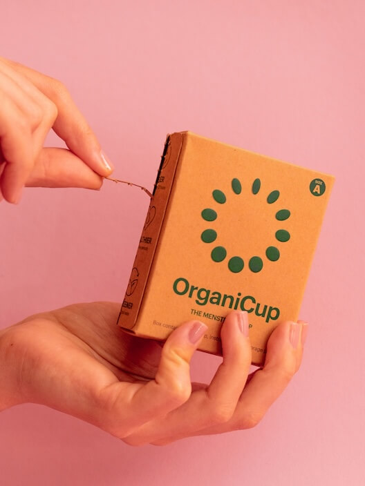 person holding brown and green cardboard box