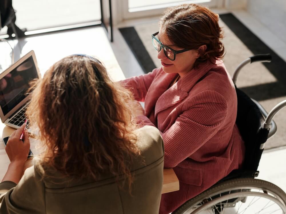 Woman in Red Sweater Wearing Black Framed Eyeglasses Sitting on Wheelchair