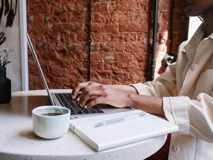 Person in White Long Sleeve Shirt Using Macbook Pro
