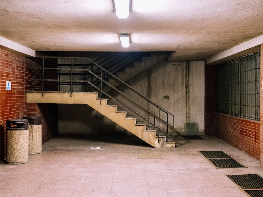 brown concrete staircase with stainless steel railings