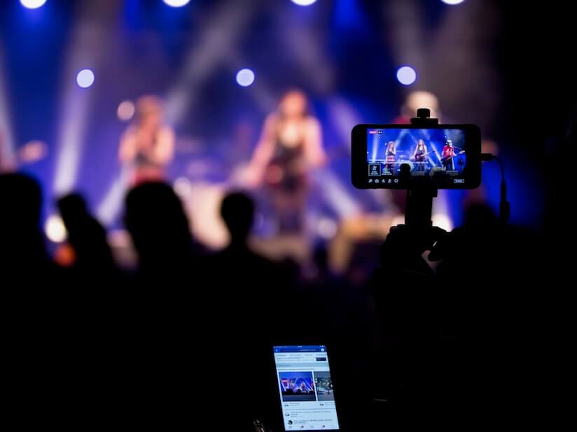 people taking videos during concert