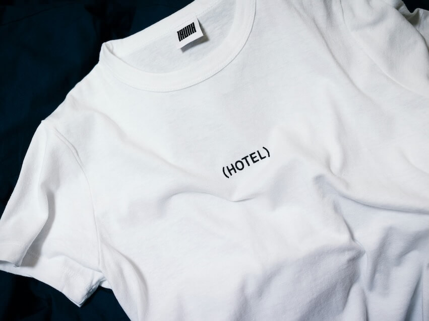 white hotel printed crew neck shirt on black surface