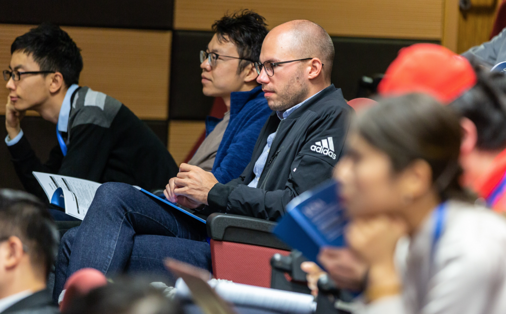 Man Wearing Black Adidas Jacket Sitting on Chair Near Another Man Wearing Blue Jacket