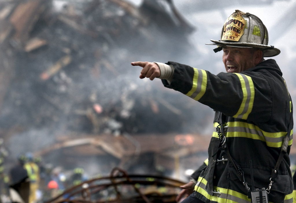 Fire Fighter Wearing Black and Yellow Uniform Pointing for Something
