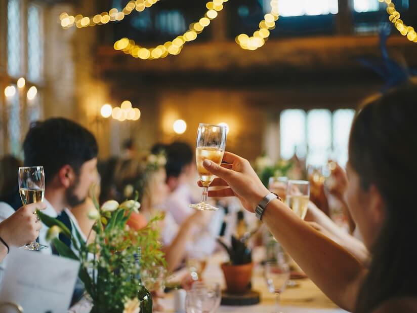 people raising wine glass in selective focus photography