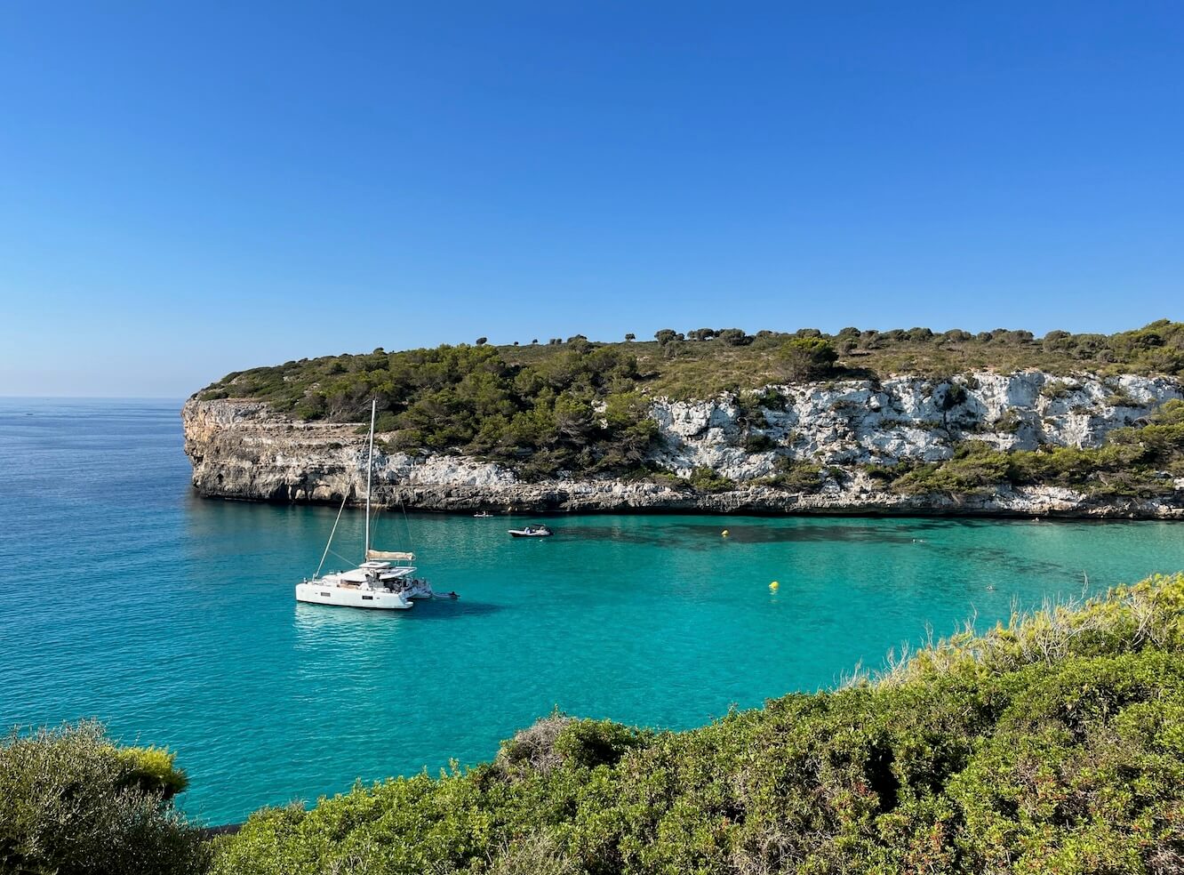 a yacht near the shore under blue sky