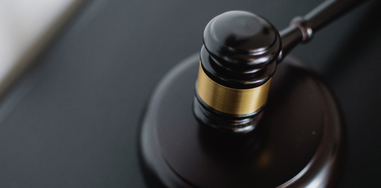 Close-up of a wooden gavel on a desk, symbolizing justice and legal authority FEATURED IMAGE