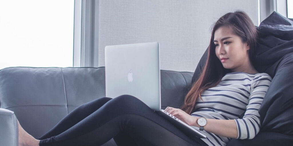 Asian Woman on couch with laptop