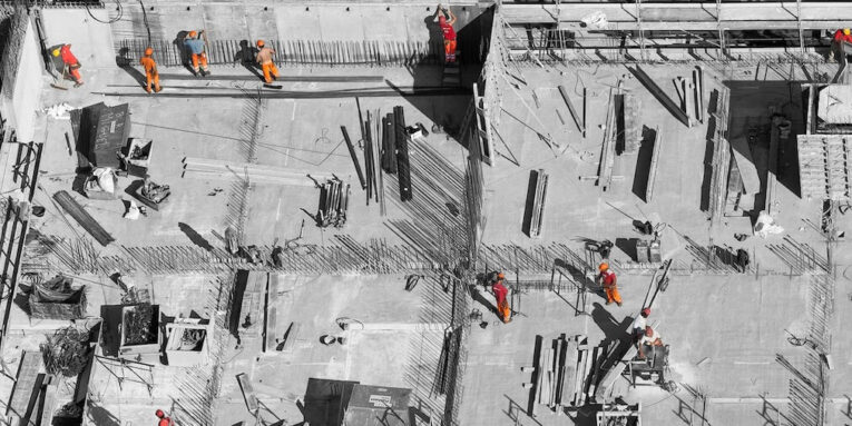 selective color photo of man on top of gray building