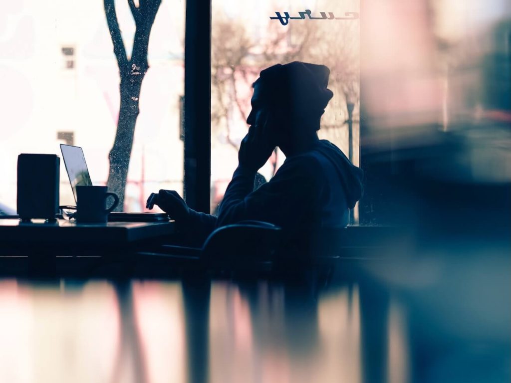silhouette of a person sitting in front of a laptop feature