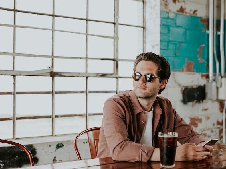 man sitting on chair holding phone