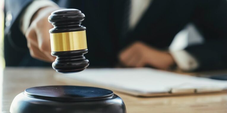 justice and lawfirm concept male lawyer in the office with brass scale FEATURED IMAGE