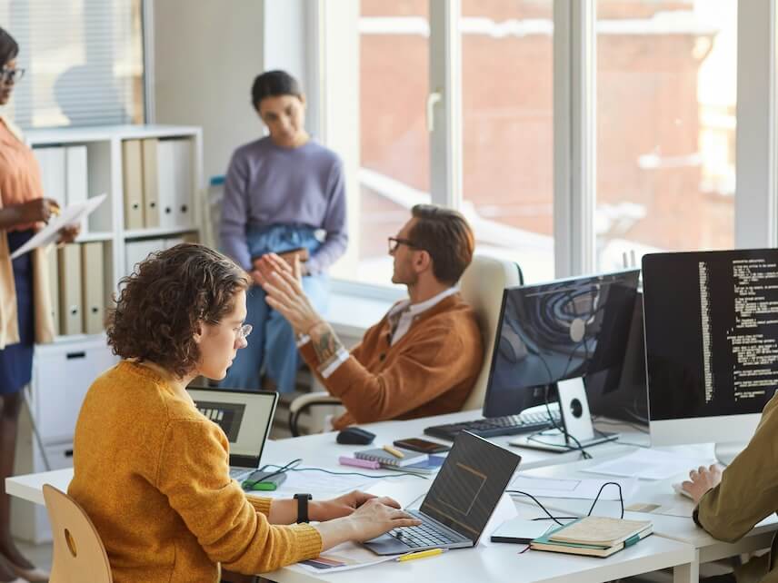 diverse team of young software programmers using computers and writing code while collaborating on project in it development studio copy space