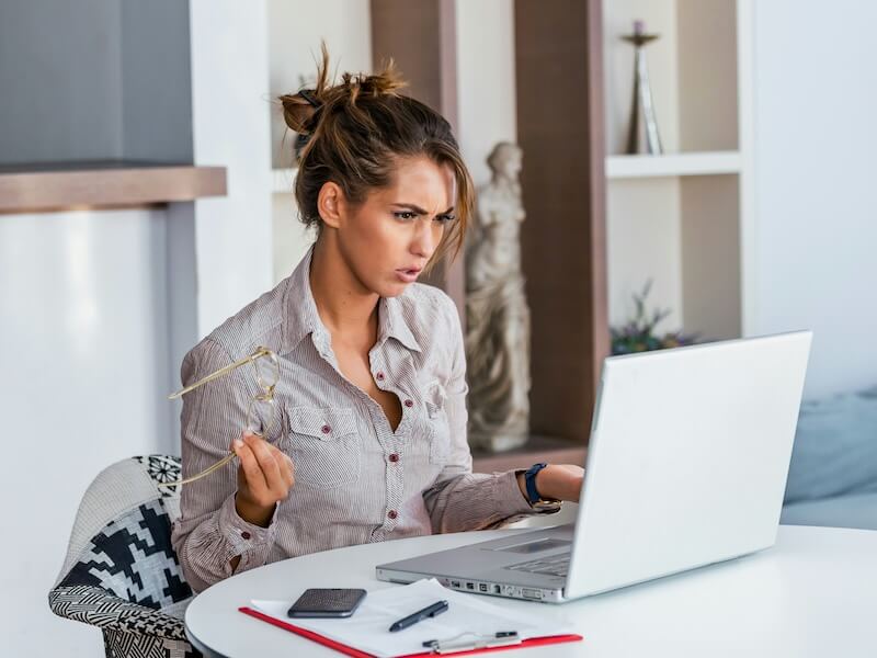 young businesswoman misunderstanding her laptop at her desk in office