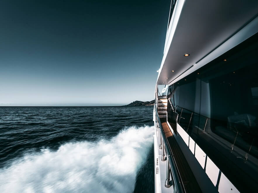 white and black yacht on sea under blue sky during daytime