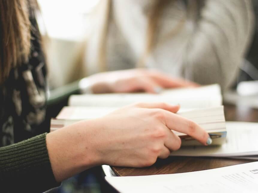 woman sitting on chair in front of table white reading book