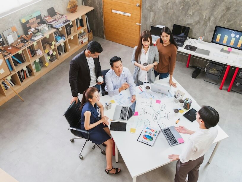 group of asian entrepreneurs and creative designer meeting in office top view