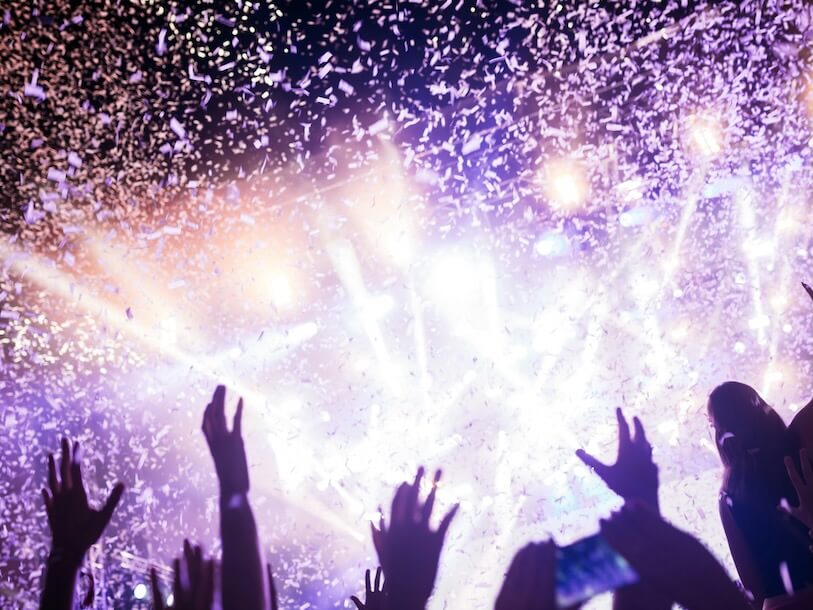 portrait of happy crowd enjoying and dancing at music festival