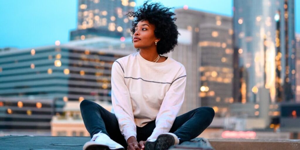 woman in white shirt and black pants sitting on gray concrete bench FEATURED IMAGE