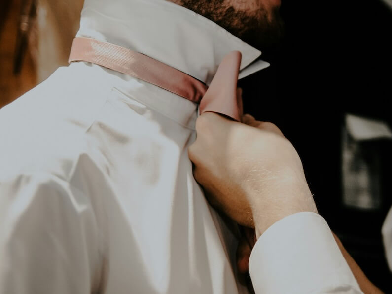 a close up of a person tying a tie