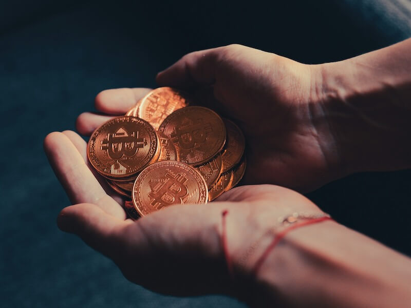 a person holding a pile of coins in their hands