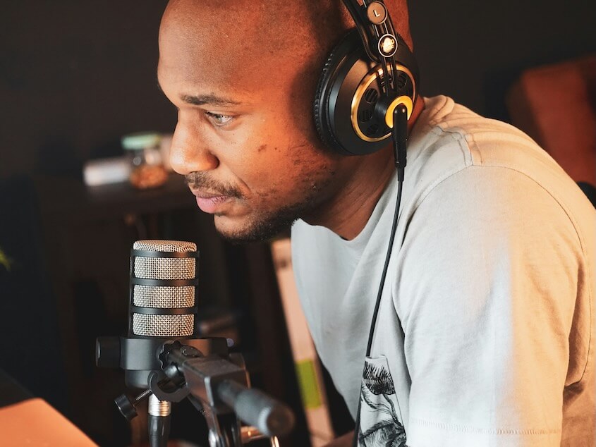 a man wearing headphones sitting in front of a microphone
