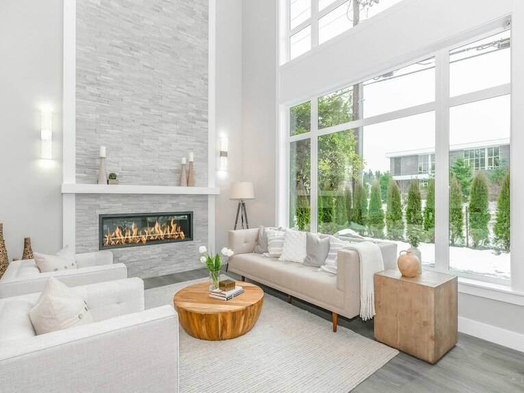 white couch near glass window and fireplace