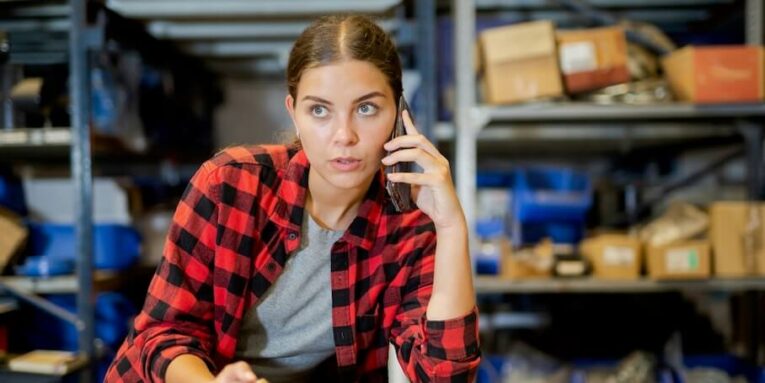 female worker takes an order on a mobile phone and makes notes in a notebook FEATURED IMAGE