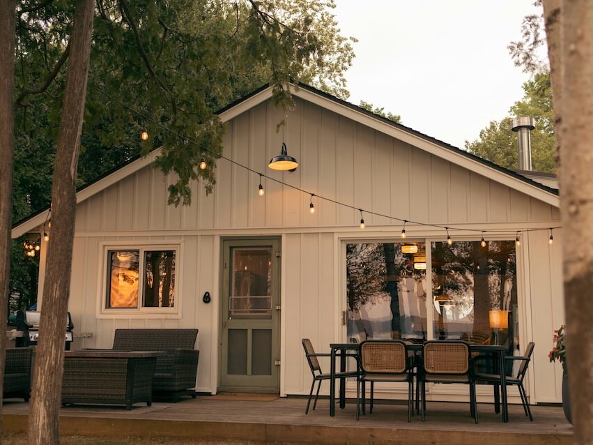 a small white house with a table and chairs outside