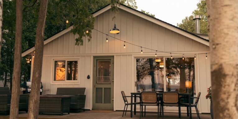 a small white house with a table and chairs outside FEATURED IMAGE