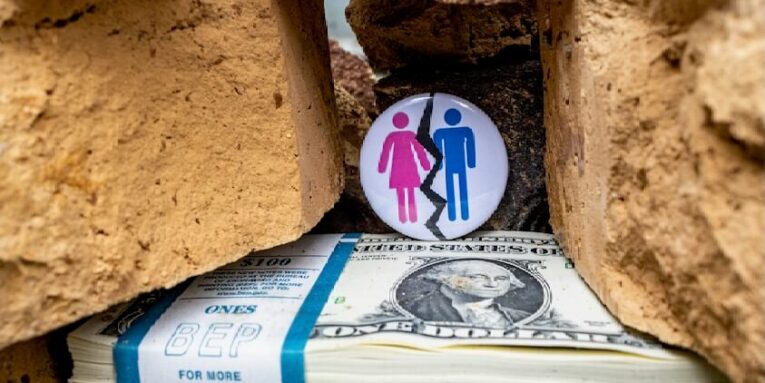 a pile of money with a button on top of it FEATURED IMAGE