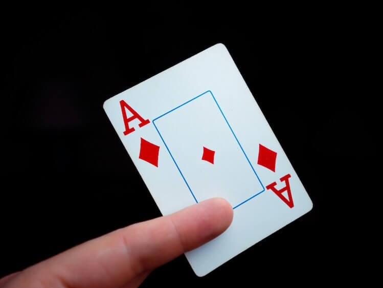 a hand holding a four of a kind playing card