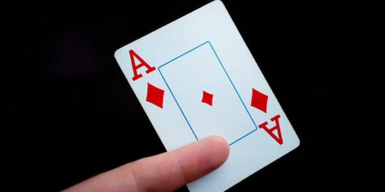 a hand holding a four of a kind playing card FEATURED IMAGE