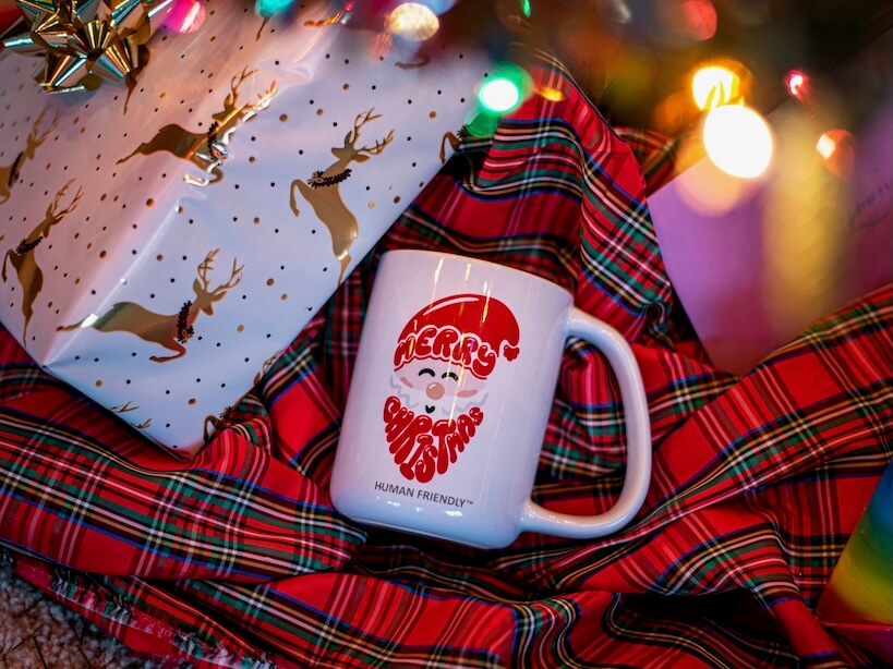 a white coffee mug sitting on top of a plaid blanket