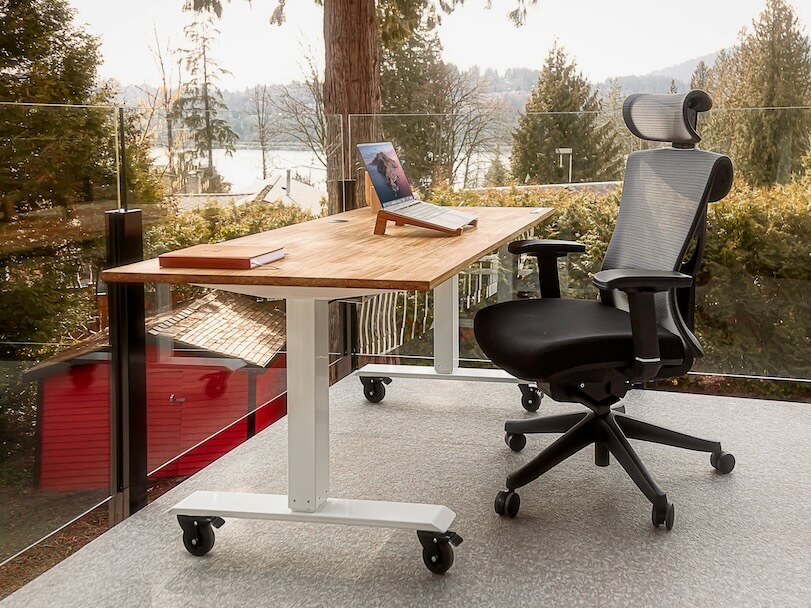 an executive office chair,  desk with a laptop on top of it 