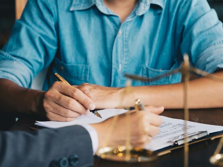judge gavel with justice lawyers having team meeting at law firm in background notary with client in office