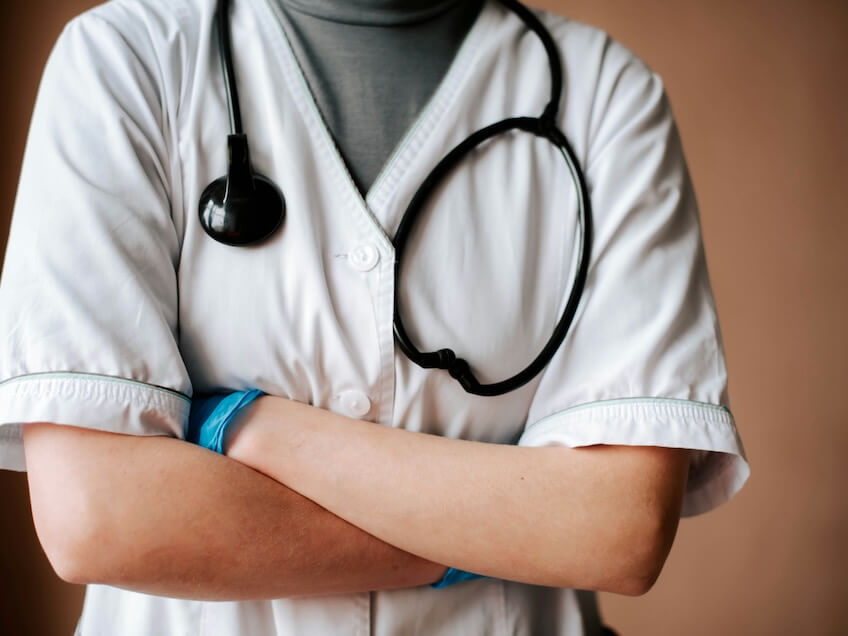 a doctor in a white uniform with a stethoscope on his arm